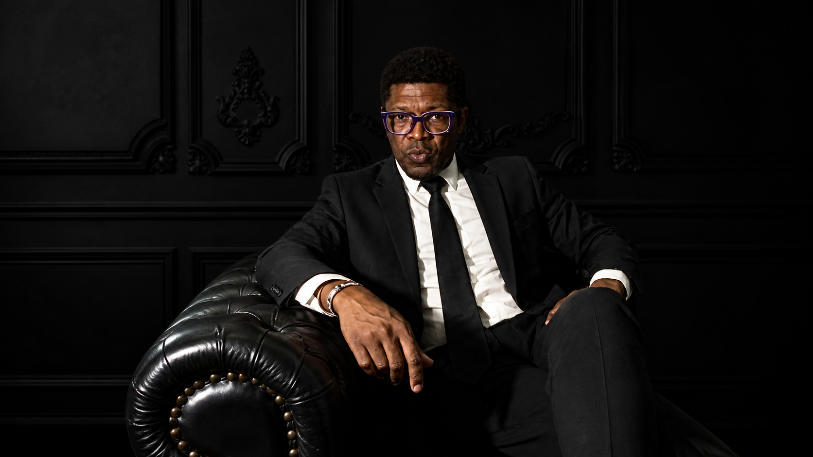 Onu Sol Adah seated in a black editorial portrait.